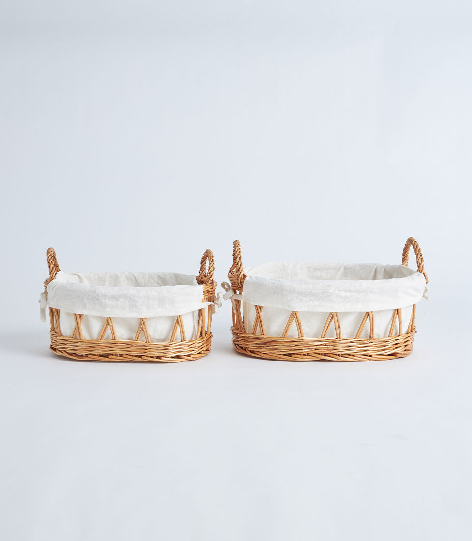 Open-weave wicker baskets with linen liners and twisted handles, light brown natural weave, gift-ready styling