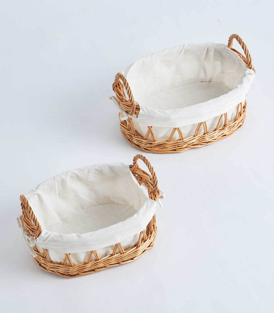 Open weave wicker baskets with white linen lining and braided handles, light natural brown craft storage or gift presentation