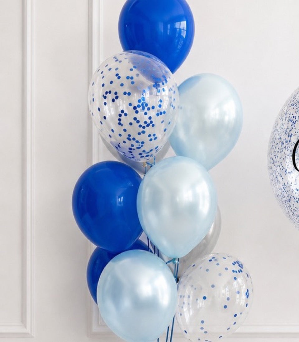 Blue, light blue, and confetti-filled latex balloons arranged in a cluster against a white wall.