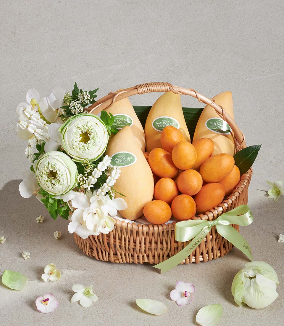 Woven wicker fruit basket with premium Nam Dok Mai mangoes, stone fruits, white lotus and orchids