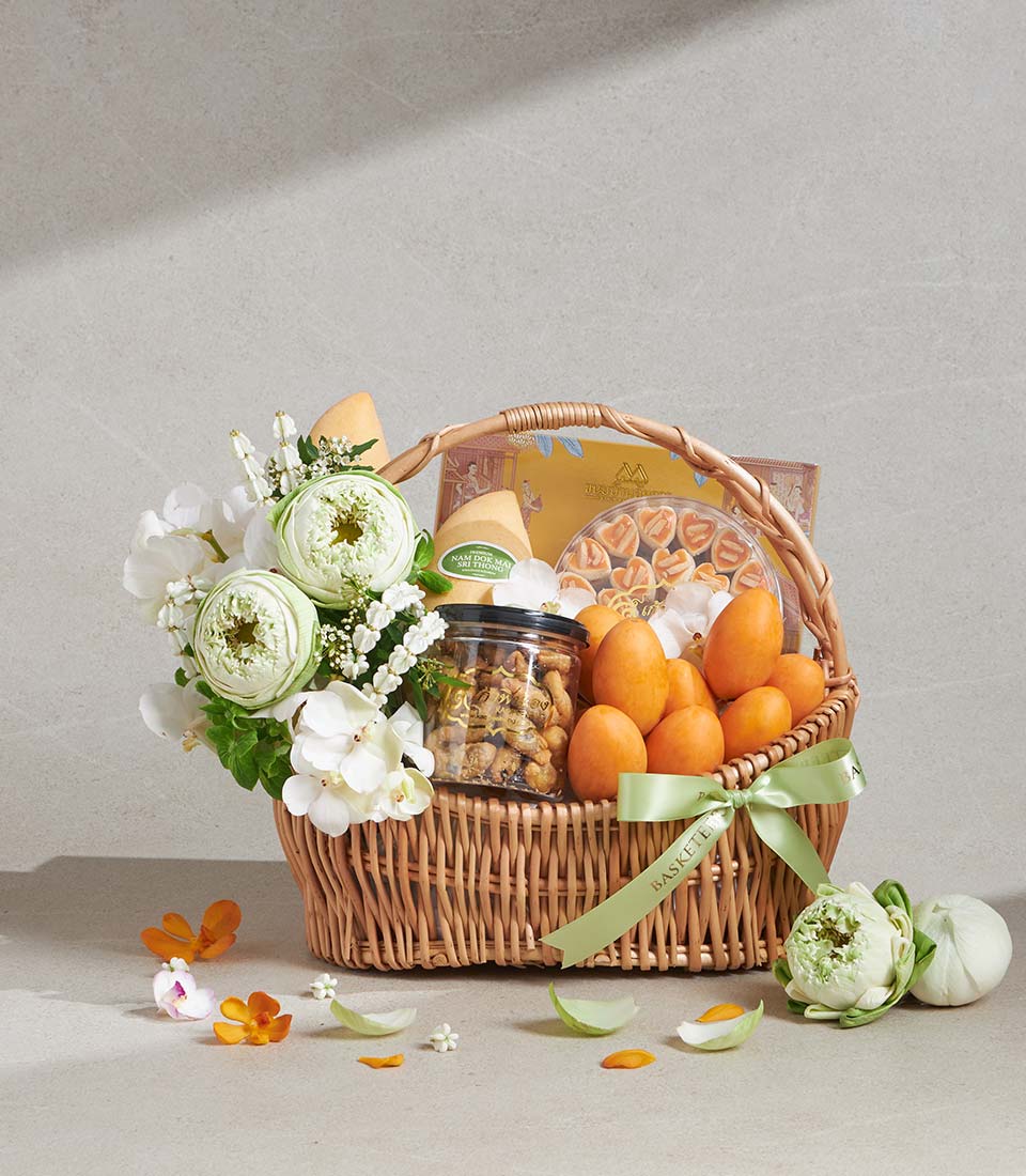 Premium wicker gift basket with white lotus and orchid flowers, gourmet treats, and heart-shaped cookies
