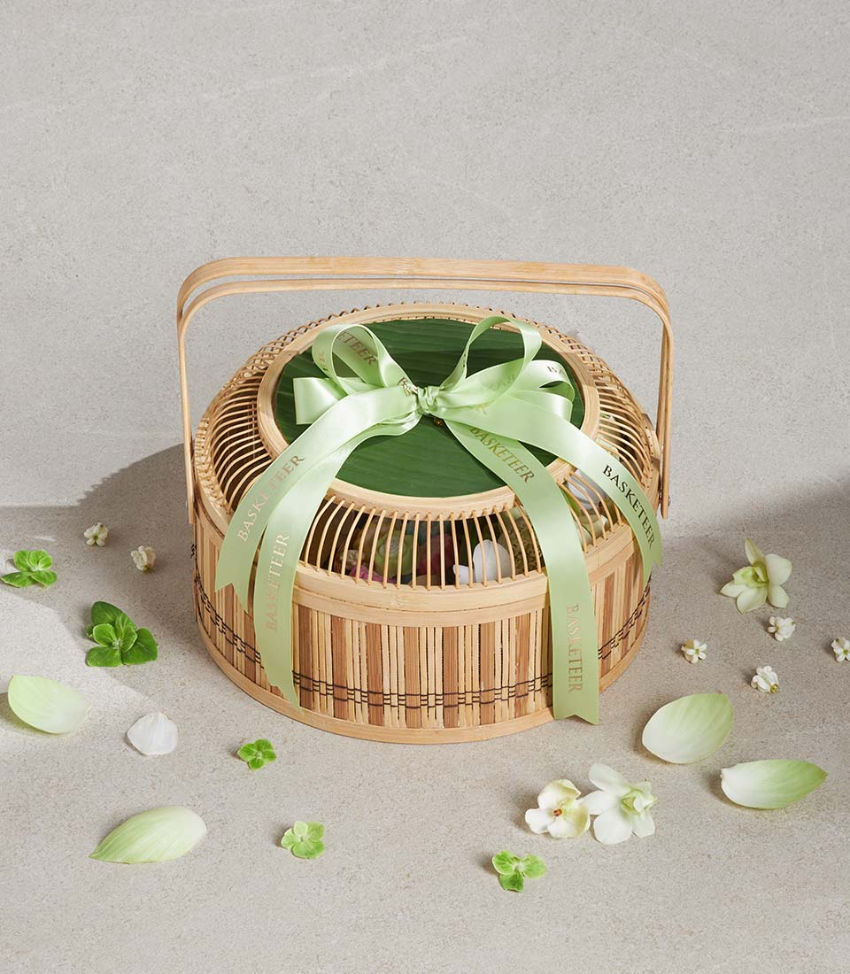 Lotus Blessing Mist luxury gift basket with two-tier bamboo design, green leaf wrap, and fresh flower accents