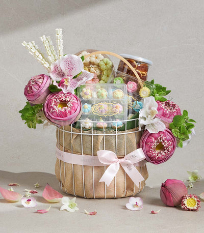 Auspicious Lotus Songkran gift basket with white wire frame, pink ribbon, pastel flower confections, and fresh pink lotus