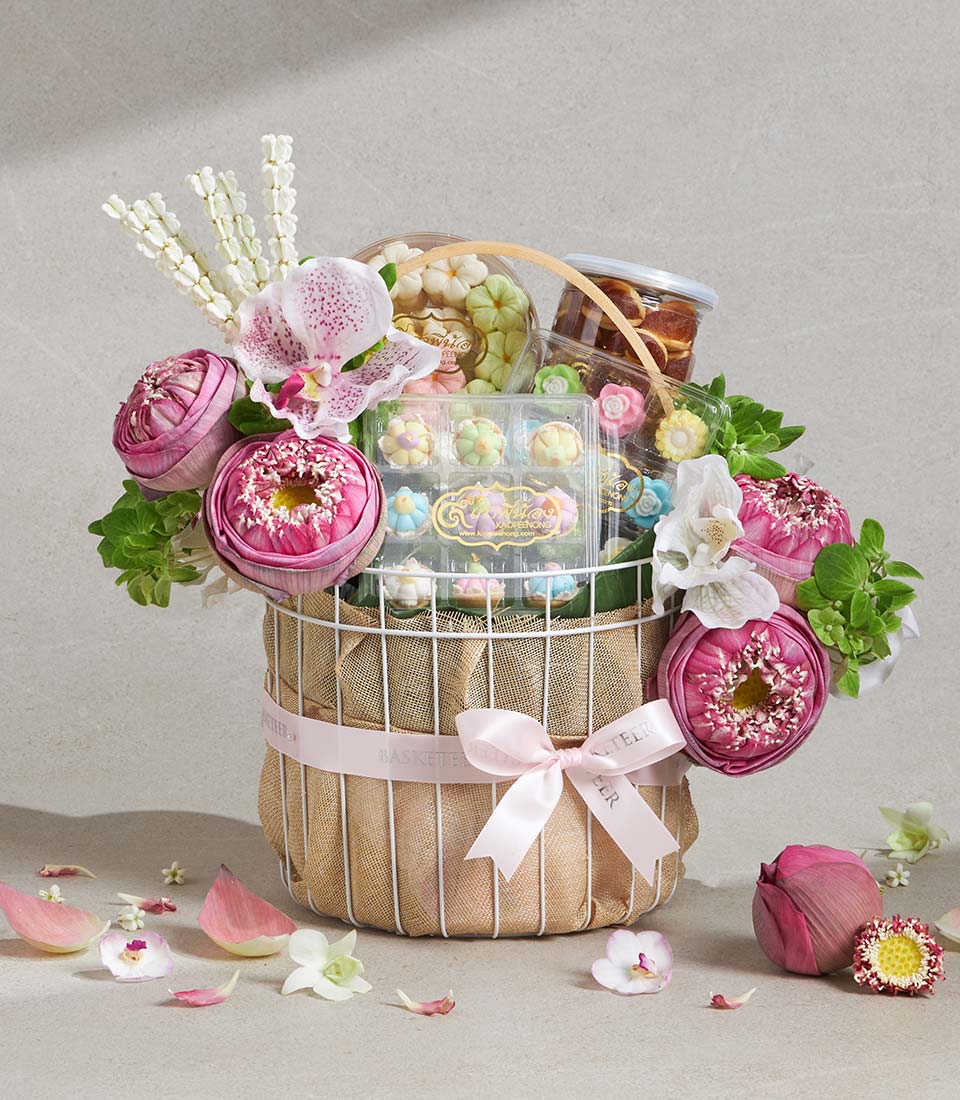 Auspicious Lotus Songkran gift basket with white wire frame, pink ribbon, pastel flower confections, and fresh pink lotus
