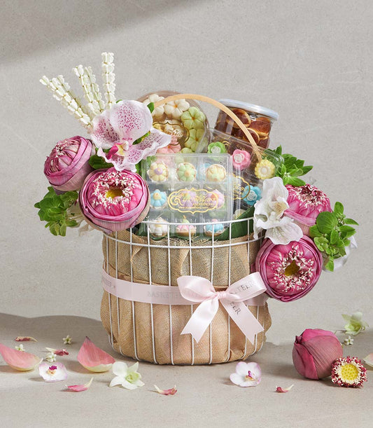 Auspicious Lotus Songkran gift basket with white wire frame, pink ribbon, pastel flower confections, and fresh pink lotus