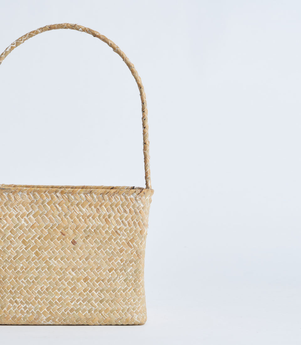 Light natural woven square basket with curved handle, ideal for gift hampers and artisan presentations