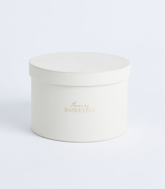 Cream cylindrical hat box with textured finish and gold Flowers by Basketeer branding for luxury gift presentation