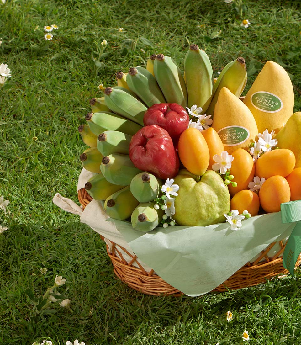 Premium Thai fruit basket with Nam Dok Mai mangoes, bananas, and rose apples in woven wicker
