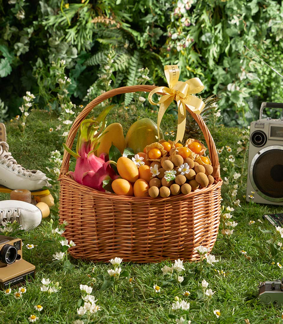 Premium Thai tropical fruit basket with dragon fruit, mango, papaya, and golden berries in wicker hamper