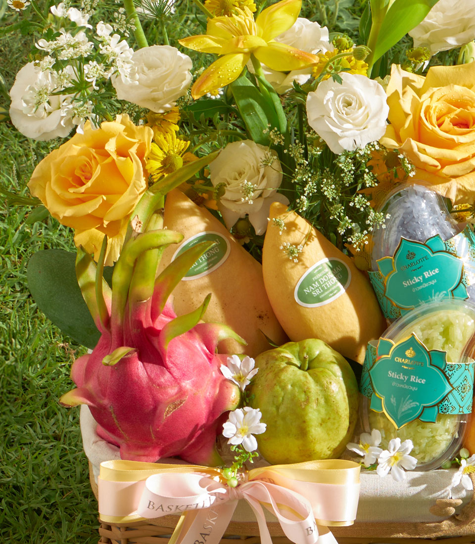 Fresh mango, dragon fruit and guava basket with yellow roses, white ranunculus and sticky rice gift set