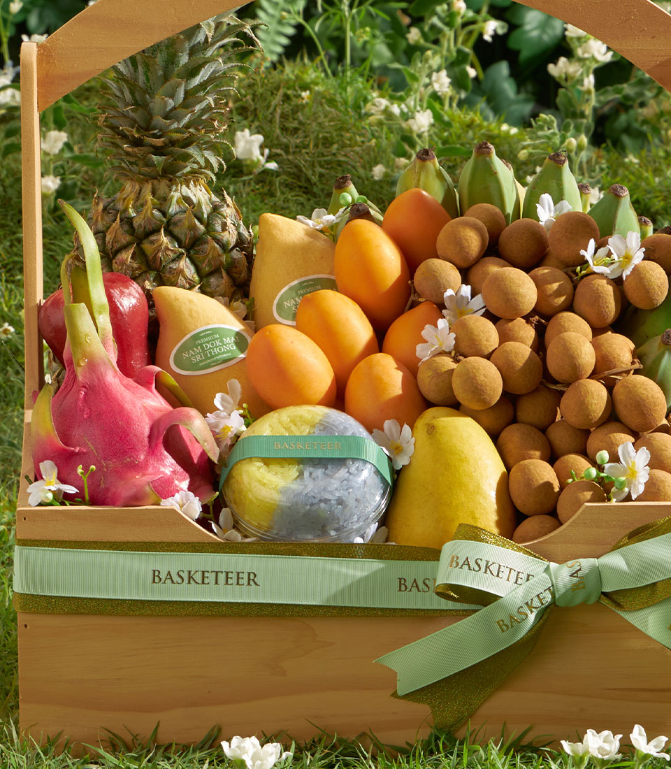 Premium Thai fruit basket with longan, mango, pineapple, and dragon fruit selection in wooden gift hamper