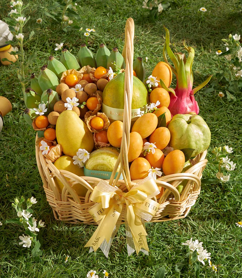 Premium Thai tropical fruit basket with mangoes, dragon fruit, and papaya in woven wicker