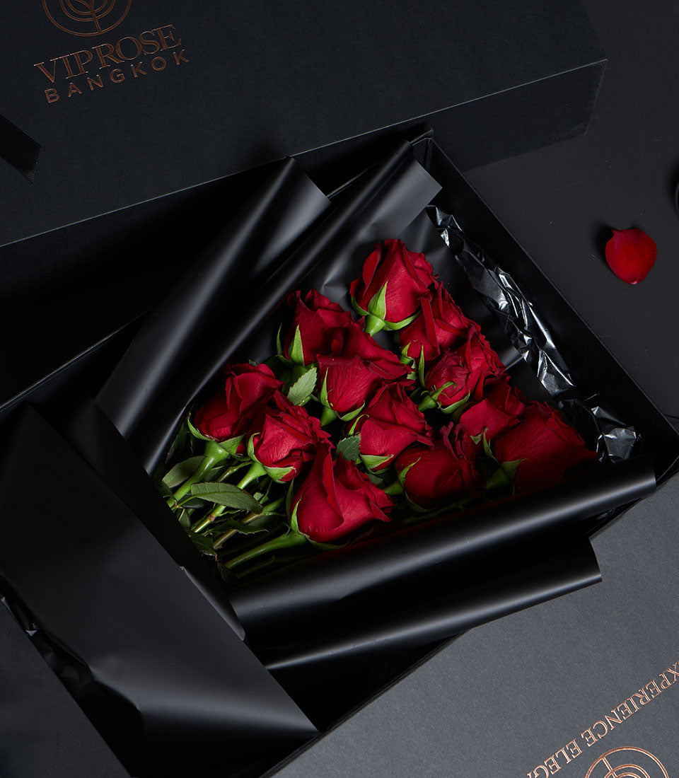 Luxury red rose bouquet in black gift box with gold branding, premium Valentine flowers from Ecuador