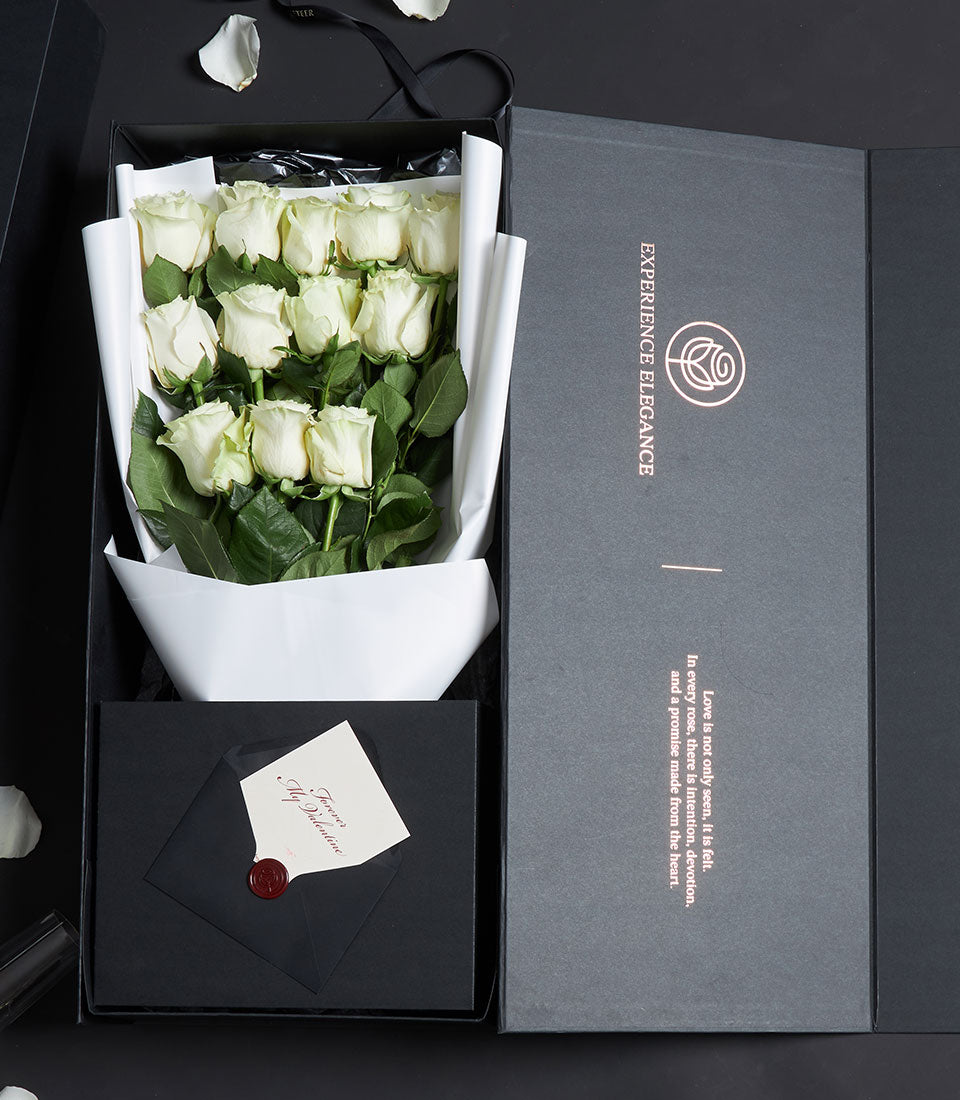 Luxury white rose bouquet with black ribbon in dark grey gift box, white card, and rose gold details for Valentine's Day