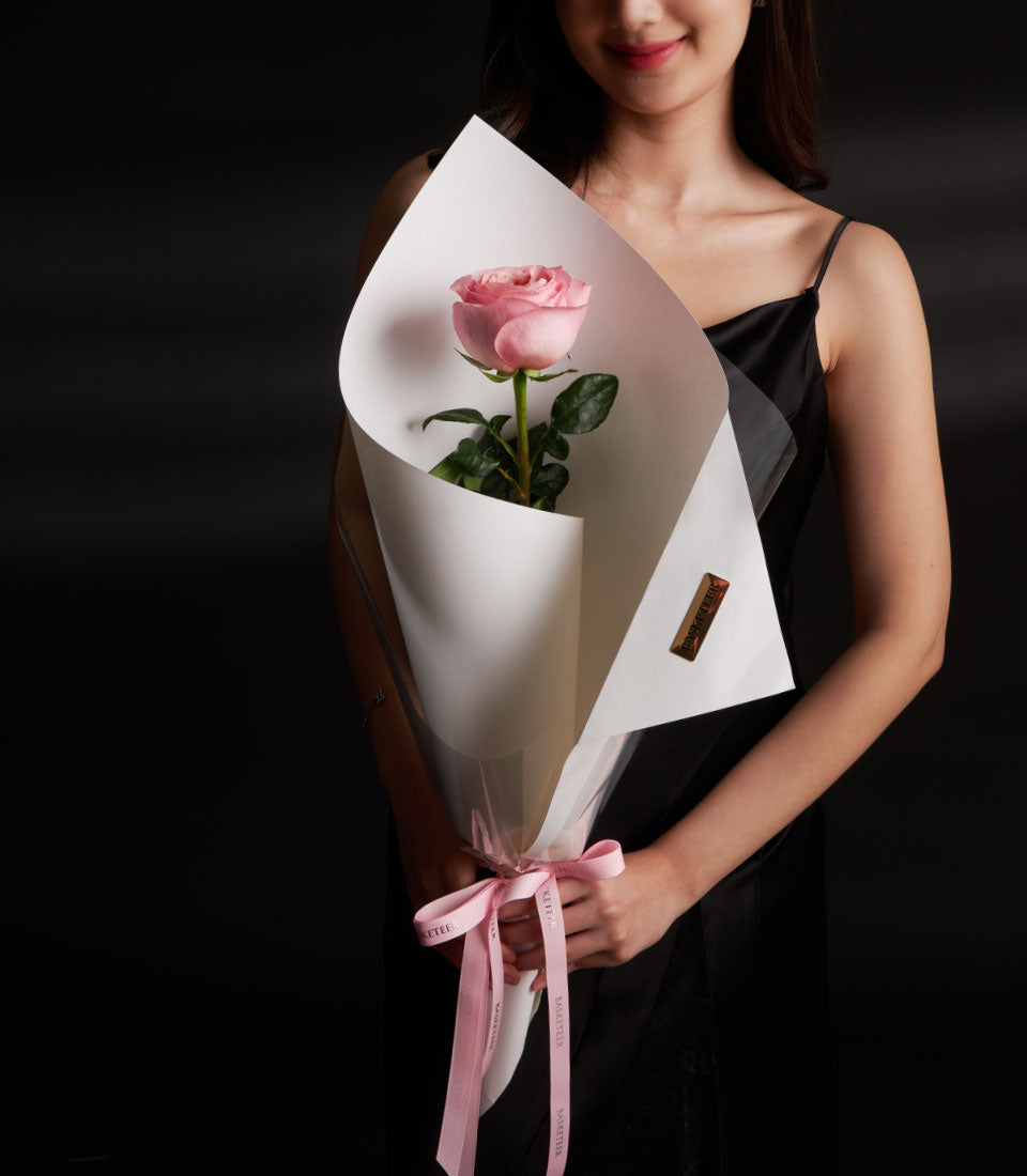 Single pink premium rose with white paper wrapping and pink ribbon bow, Valentine's Day gift