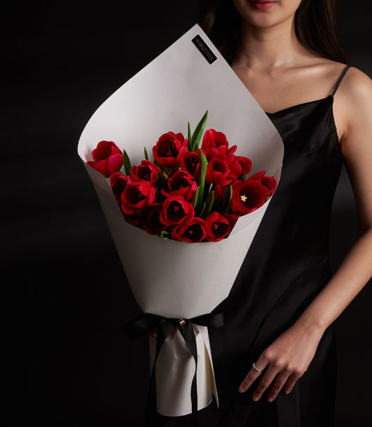 Red tulip Valentine bouquet wrapped in grey paper with black ribbon