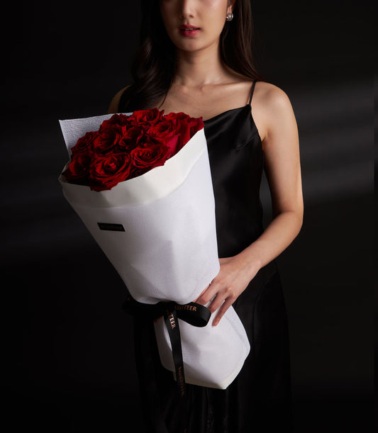 Lush red rose bouquet from Flowers by Basketeer. Premium flowers for flower delivery in Bangkok, wrapped in elegant white paper and tied with black ribbon.