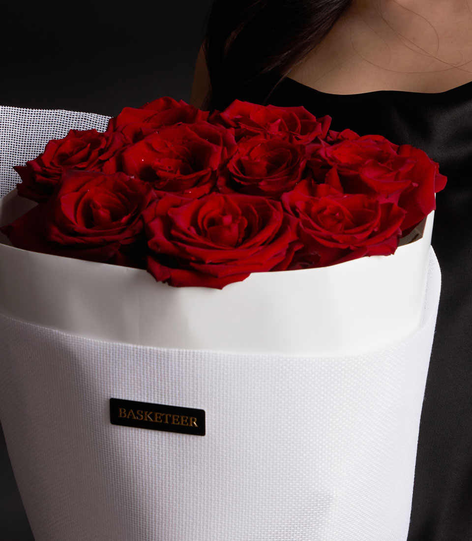Vibrant red Ecuador roses in white cylindrical gift box with gold Basketeer label, Valentine's Day bouquet