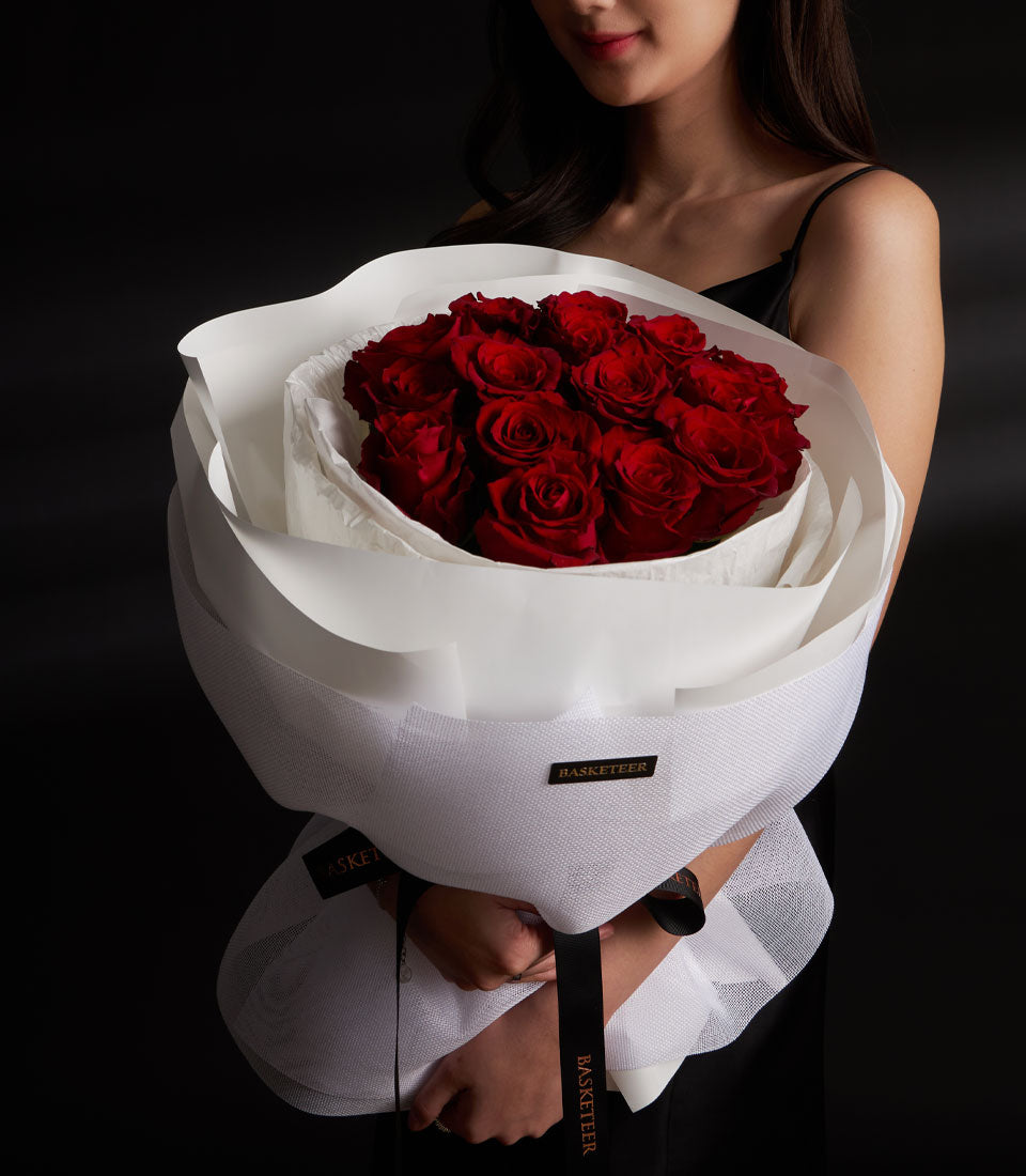 Lush red rose bouquet from Flowers by Basketeer, expertly wrapped in elegant white paper and tied with a logo ribbon. Perfect for flower delivery Bangkok.