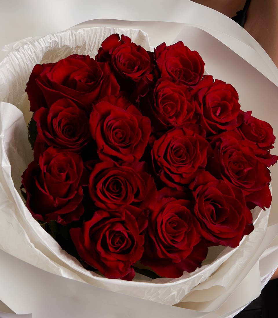 Deep red Ecuador rose bouquet with 18-20 velvety blooms in white crinkled paper wrapping