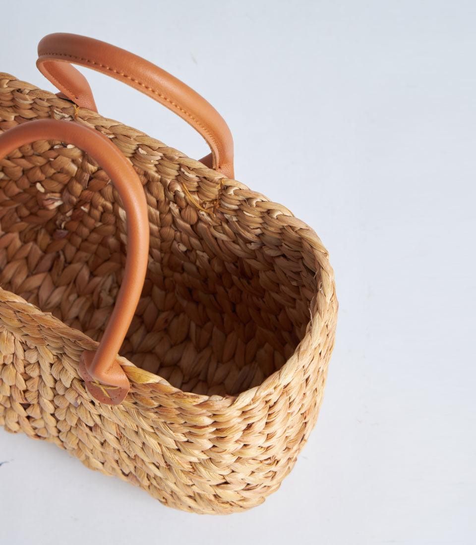 Natural woven straw tote with leather handles, artisan gift basket