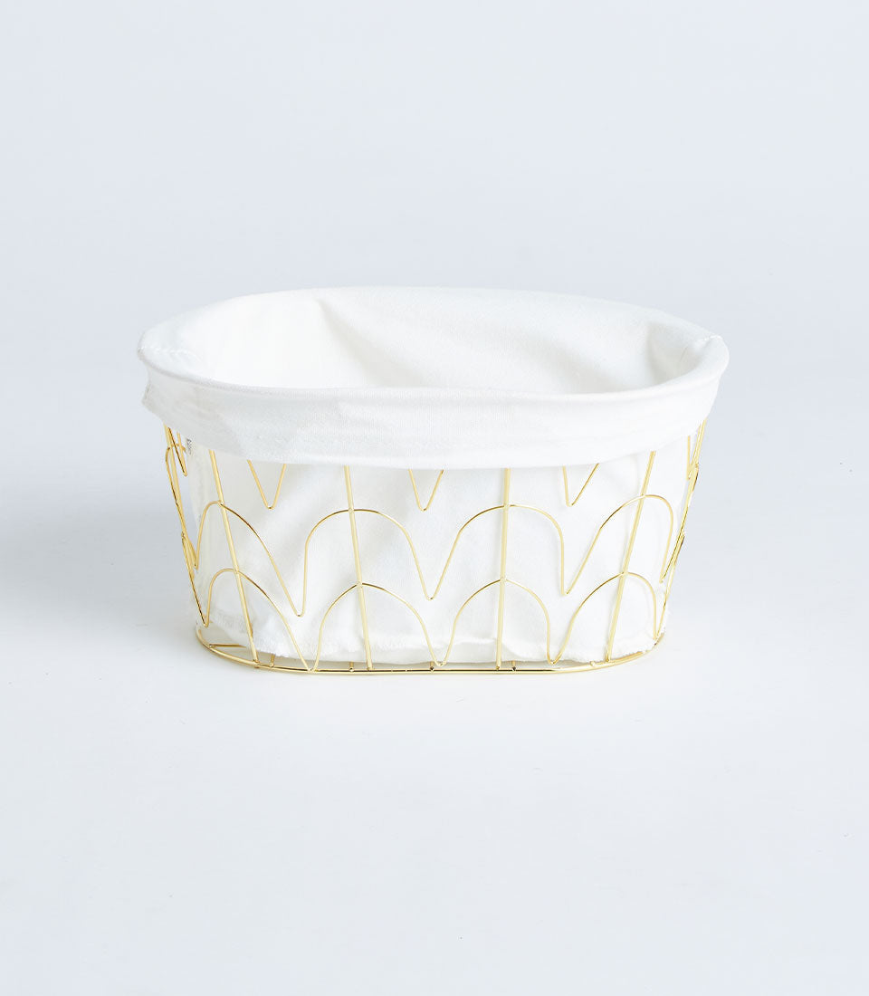 Oval gold metal wire basket with white fabric lining, artisan gift storage