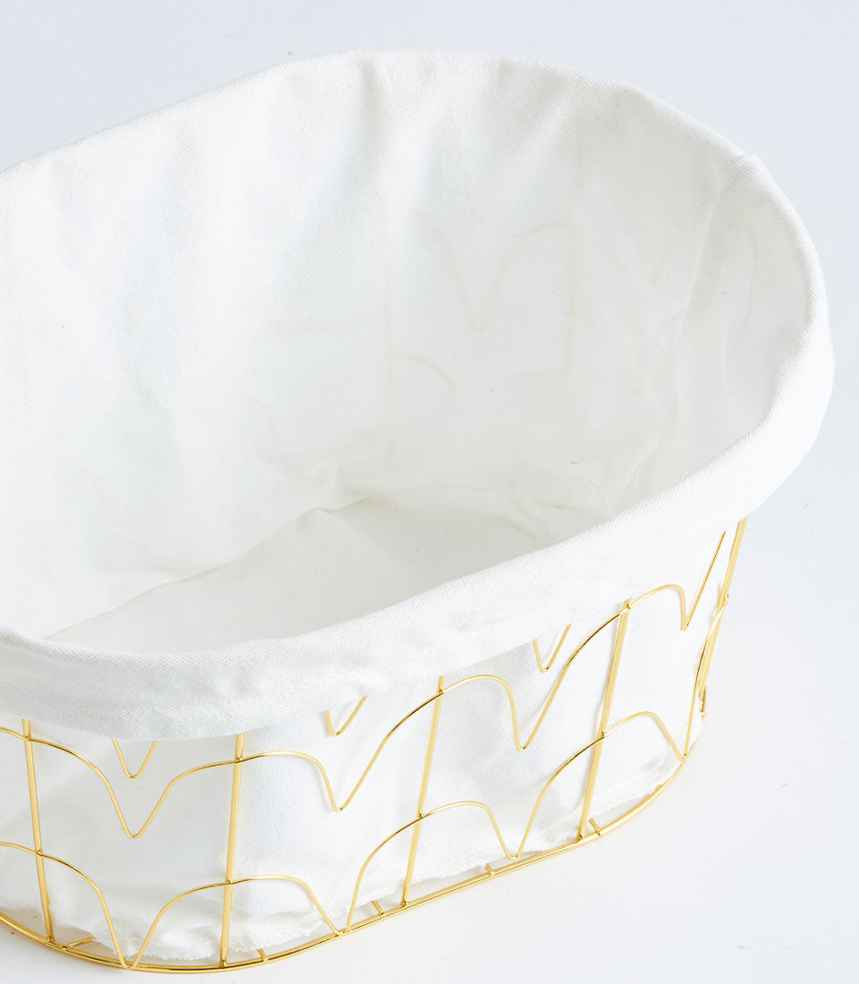 Gold metal wire basket with white fabric lining and scalloped rim detail