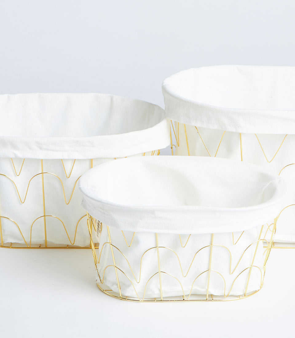Gold metal wire baskets with white fabric lining, set of three oval storage containers