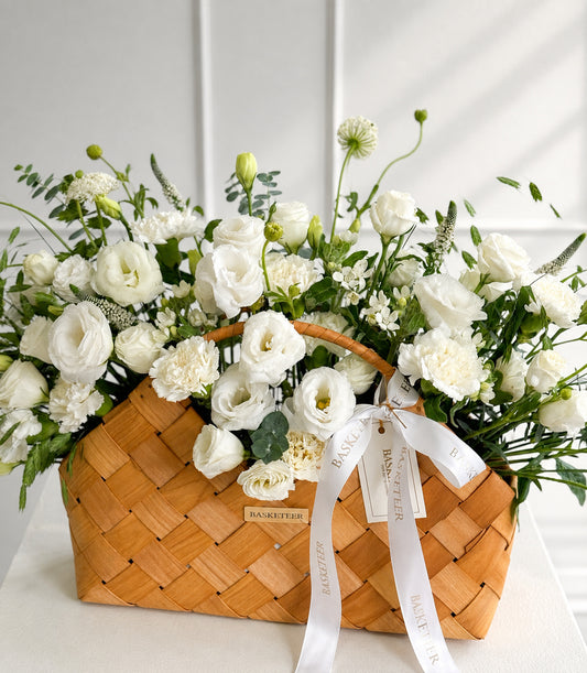 Elegant flower basket arrangement by Flowers by Basketeer, featuring lush white lis