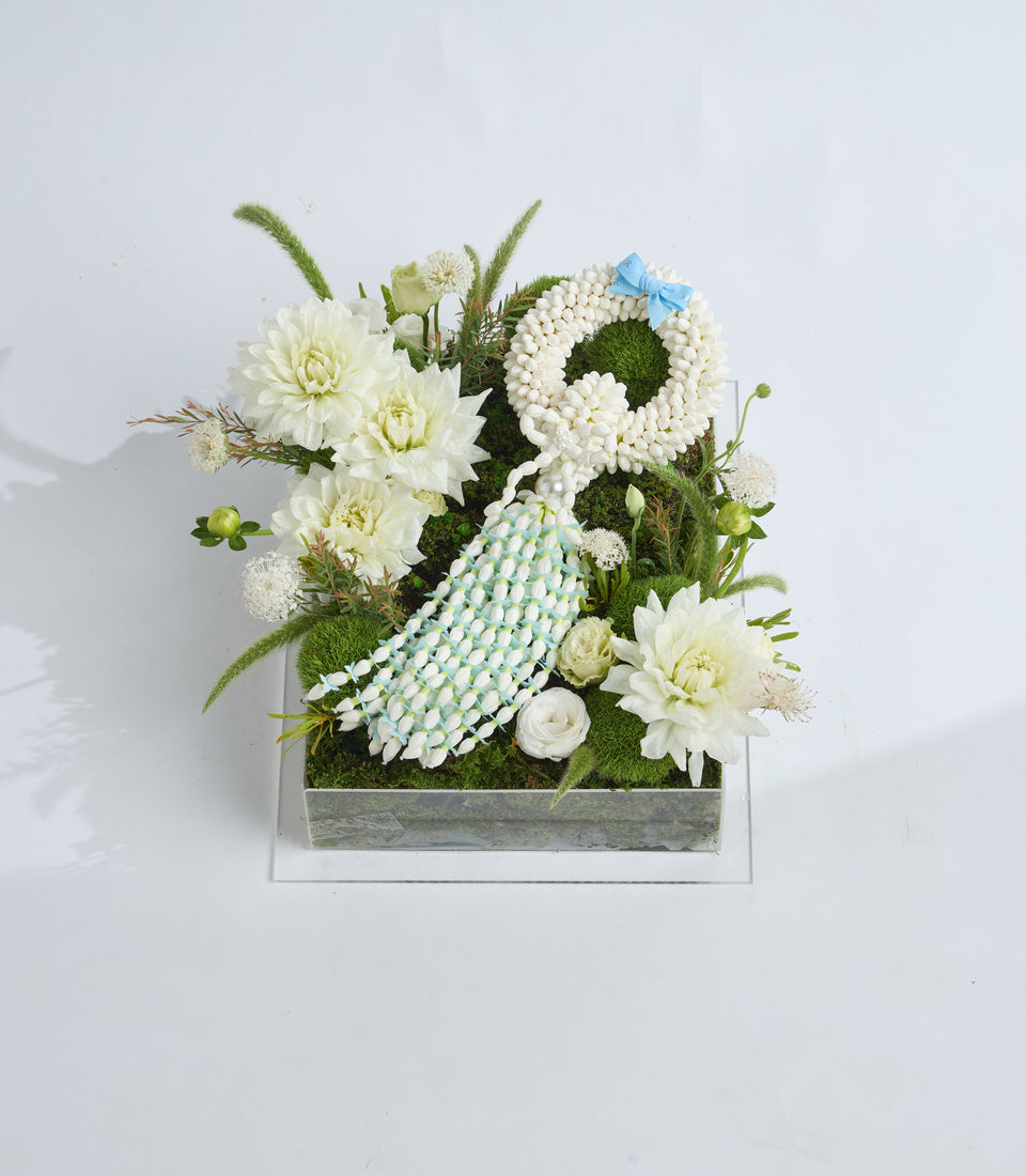 # Alt Text

Elegant floral arrangement in gray wooden box featuring white dahlias, pearl beads, moss, ornamental grasses, and blue ribbon accent on white background.