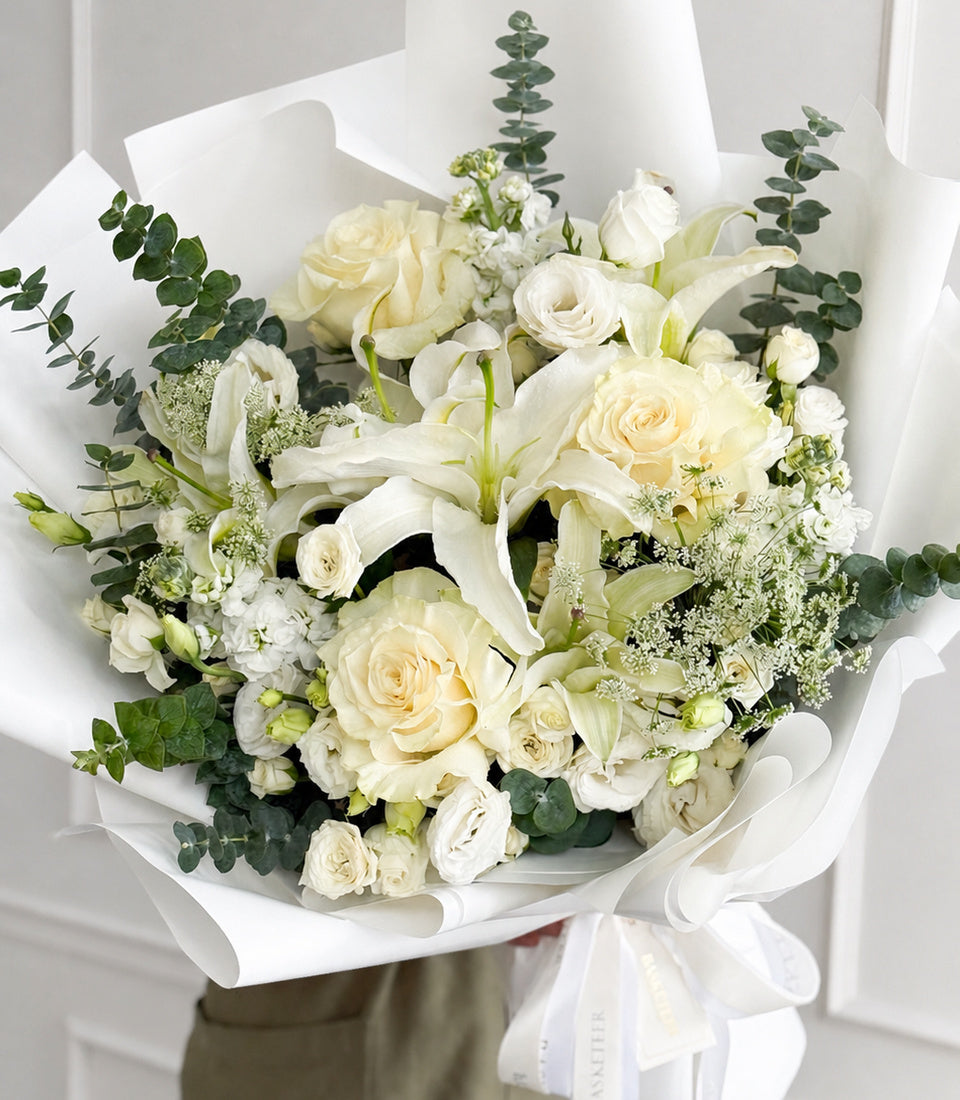Elegant white rose and lily bouquet, accented with fresh eucalyptus and baby