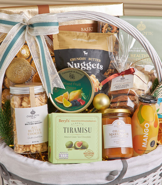 White woven New Year gift basket with teal striped ribbon bow, filled with gourmet coconut roll, chocolate cookies, mixed