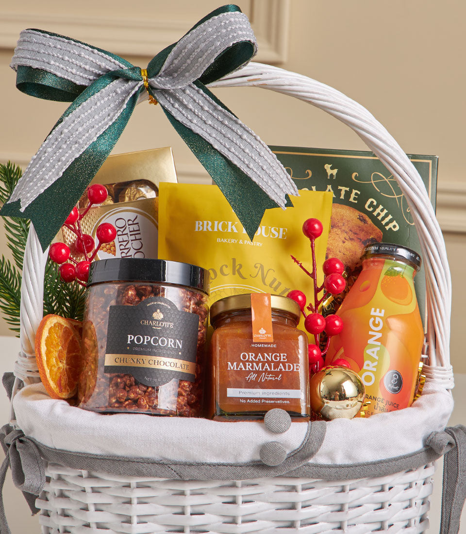 Luxury gourmet gift hamper with chocolate chip cookies, popcorn, orange marmalade and fresh juices for New Year gifting