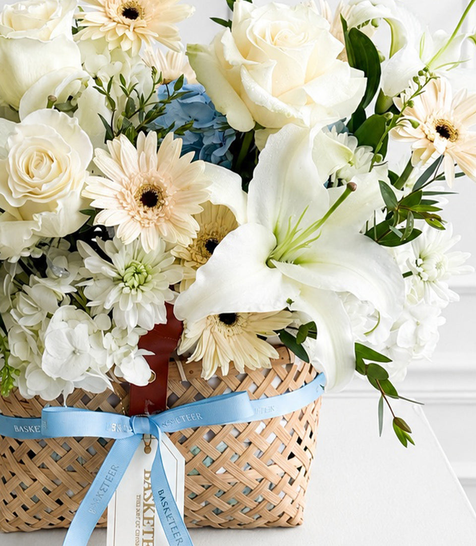 A luxurious flower basket from Flowers by Basketeer, featuring elegant white roses, fragrant