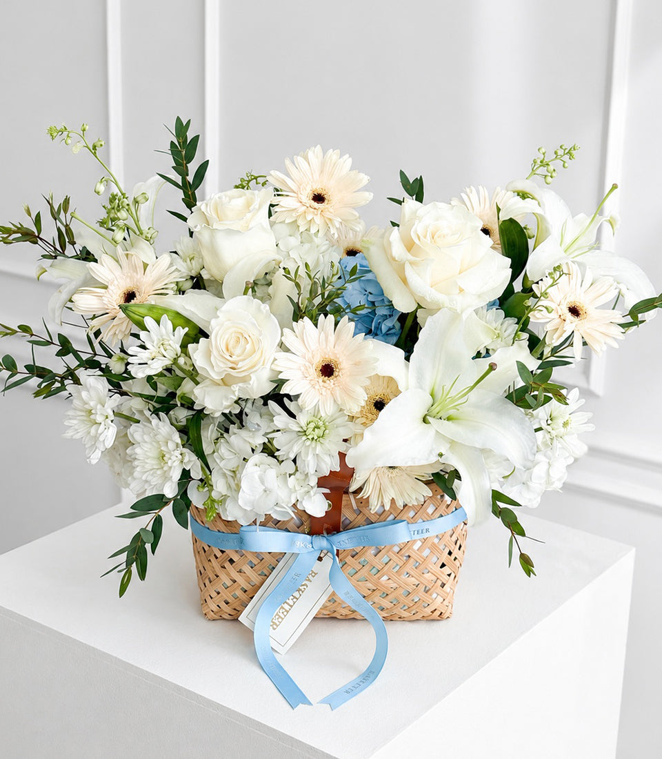 Luxurious basket arrangement by Flowers by Basketeer featuring white roses, lilies,