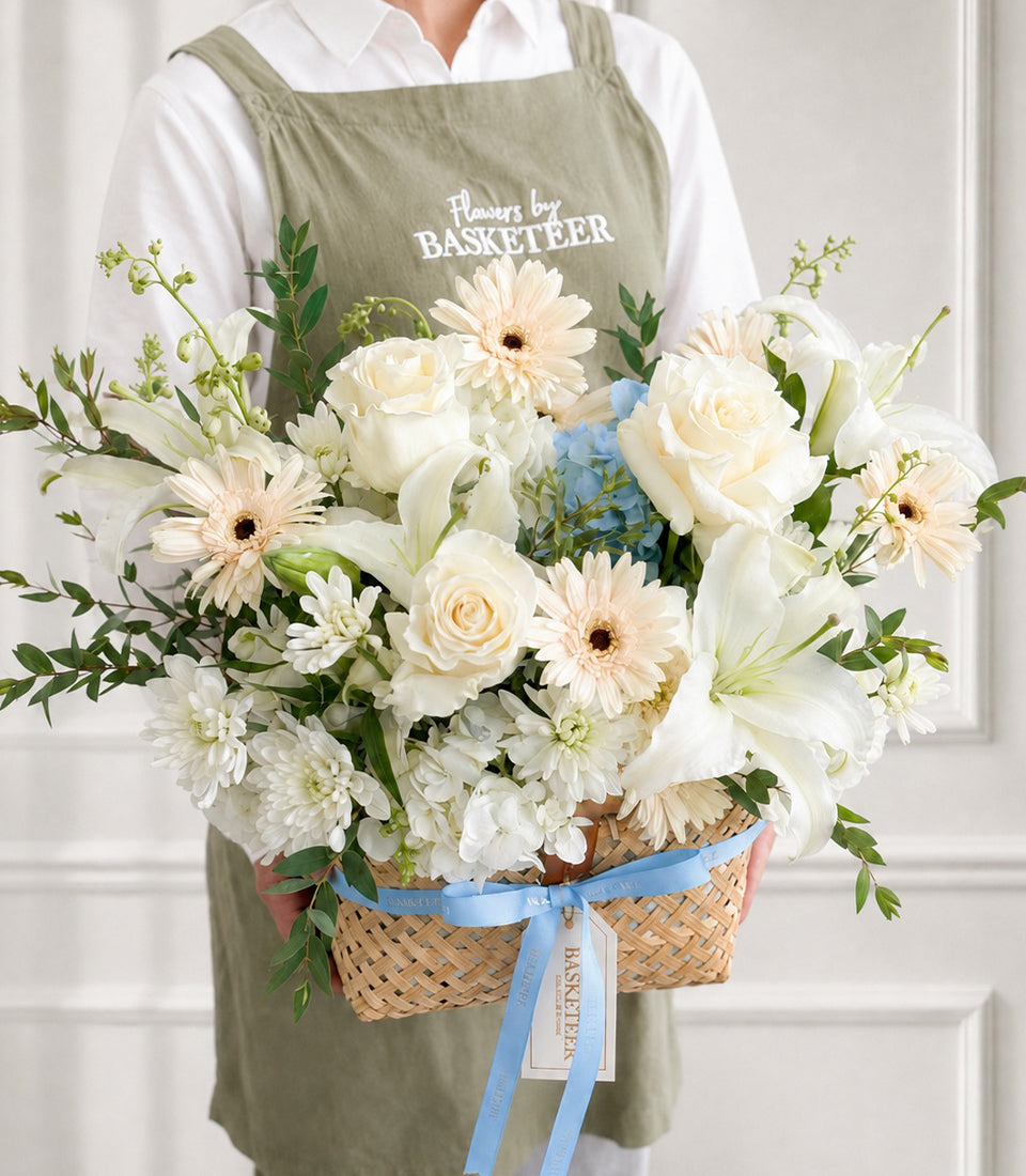Elegant flower basket arrangement by Flowers by Basketeer featuring lush white roses, lilies,