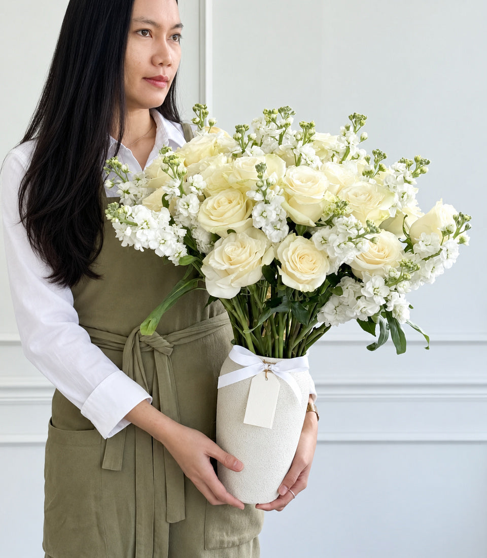 Elegant ivory rose and white stock flower arrangement by Flowers by Basketeer, presented in