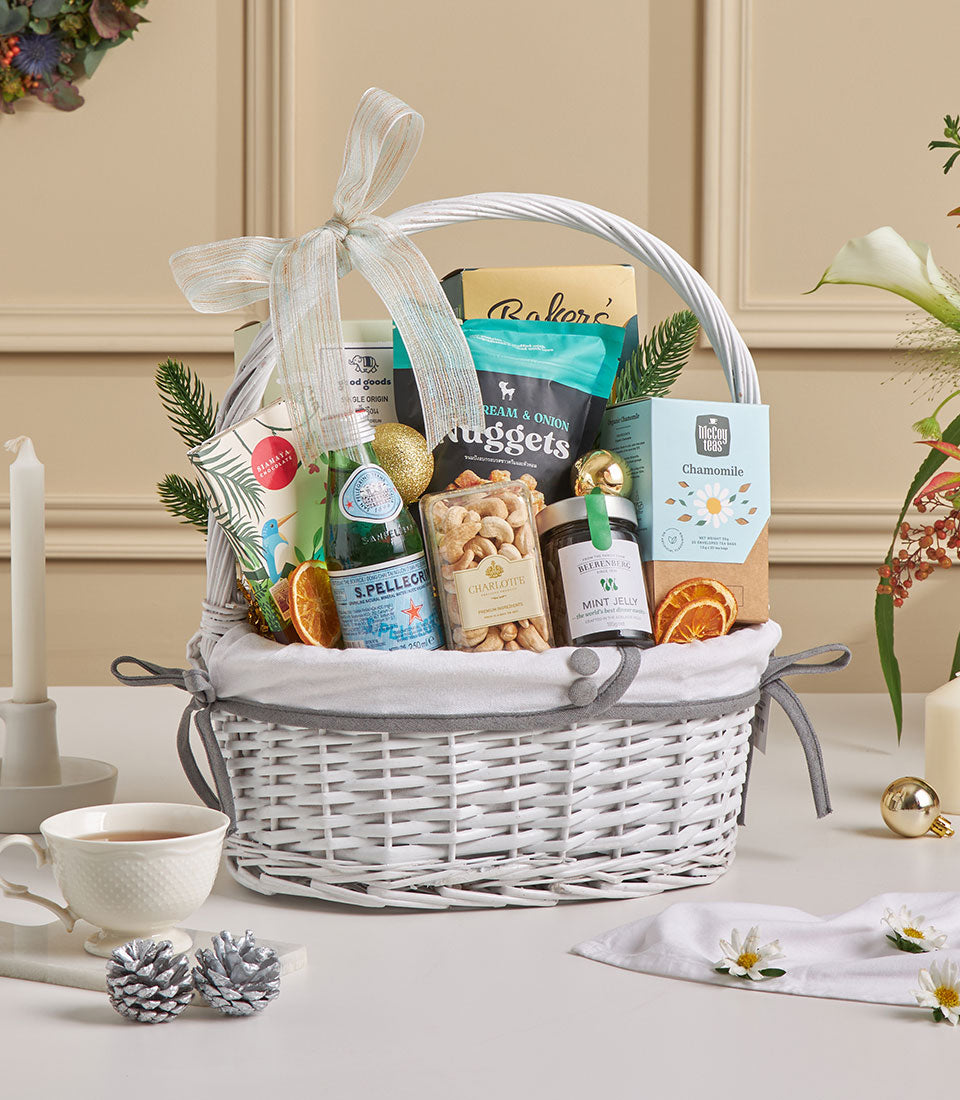 Luxe gourmet gift basket with espresso coffee, roasted cashews, sparkling water, and artisan treats, tied with blue ribbon