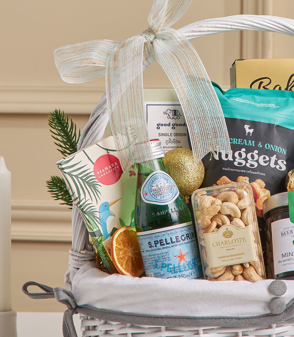 Premium New Year gift hamper with espresso, cashews, sparkling water and gourmet treats in white woven basket