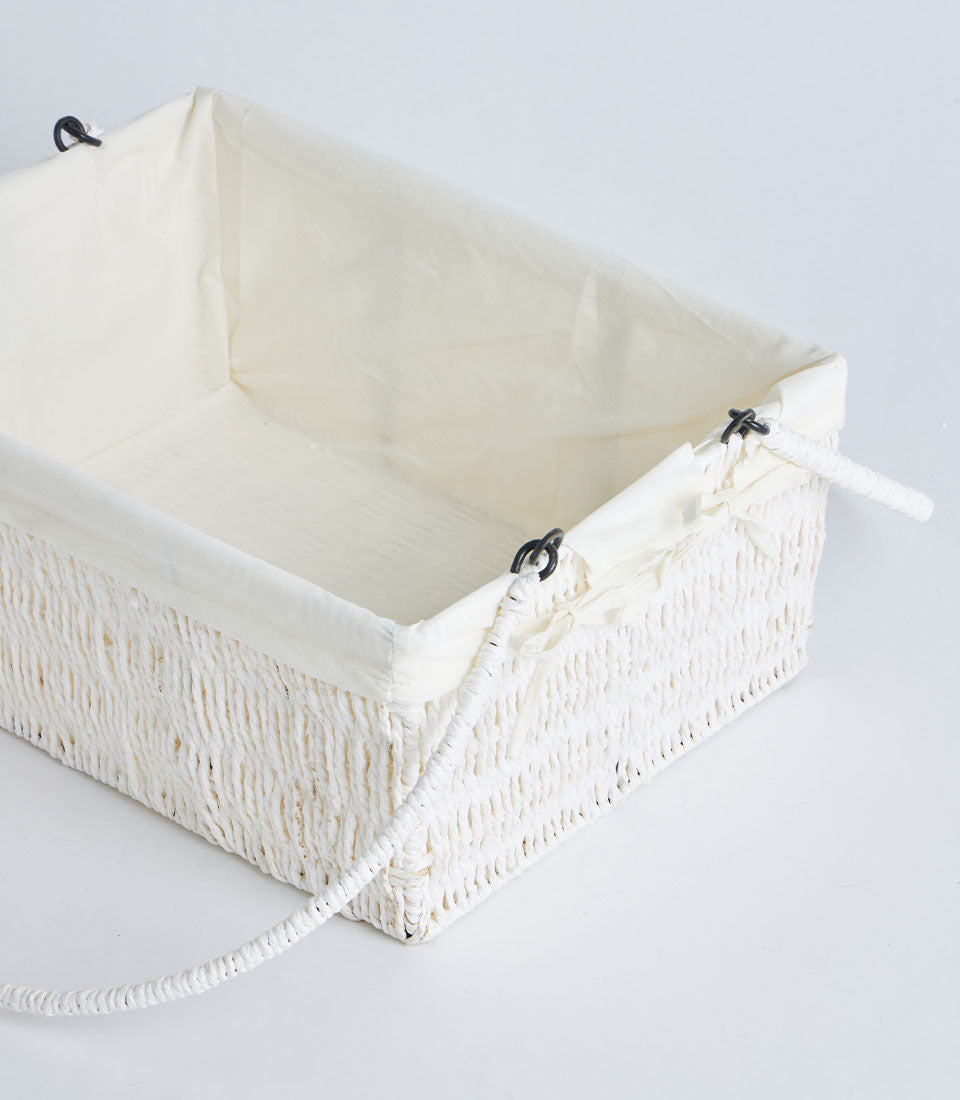 Natural woven basket with white braided rope handle and cream fabric liner for curated gift hampers